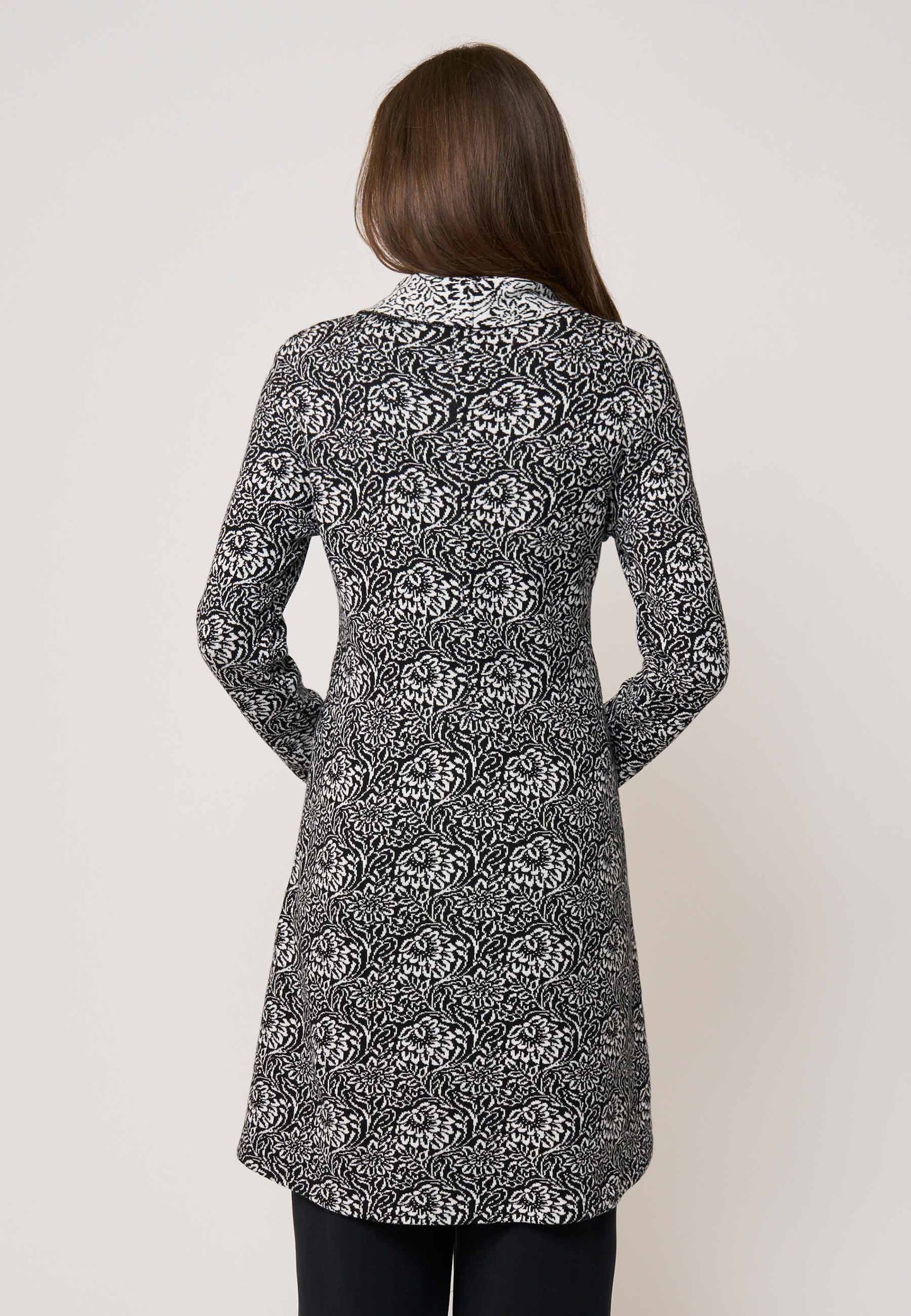 Strickjacke, Modell Jolina lang in Schwarz mit weißem floralen Muster und lockerem Schnitt, Rückansicht getragen