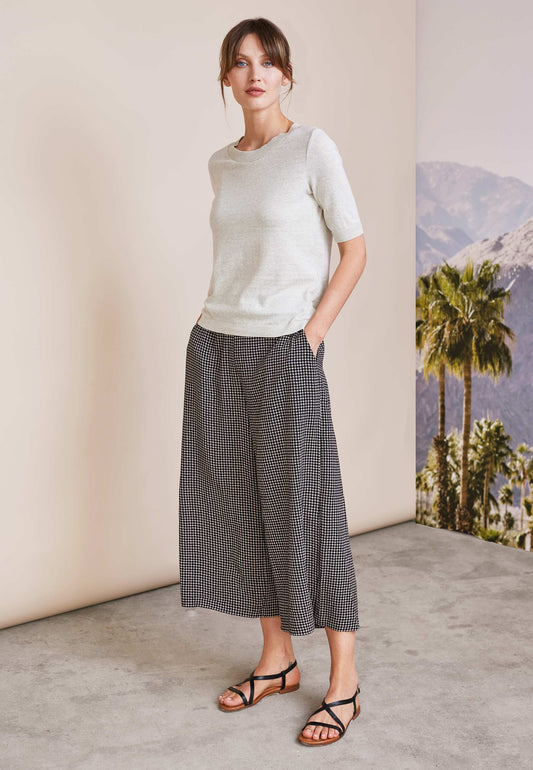 Pulli, Modell Alisa in hellem Sandton mit kurzem Arm und feiner Struktur, stehend mit Händen in den Taschen