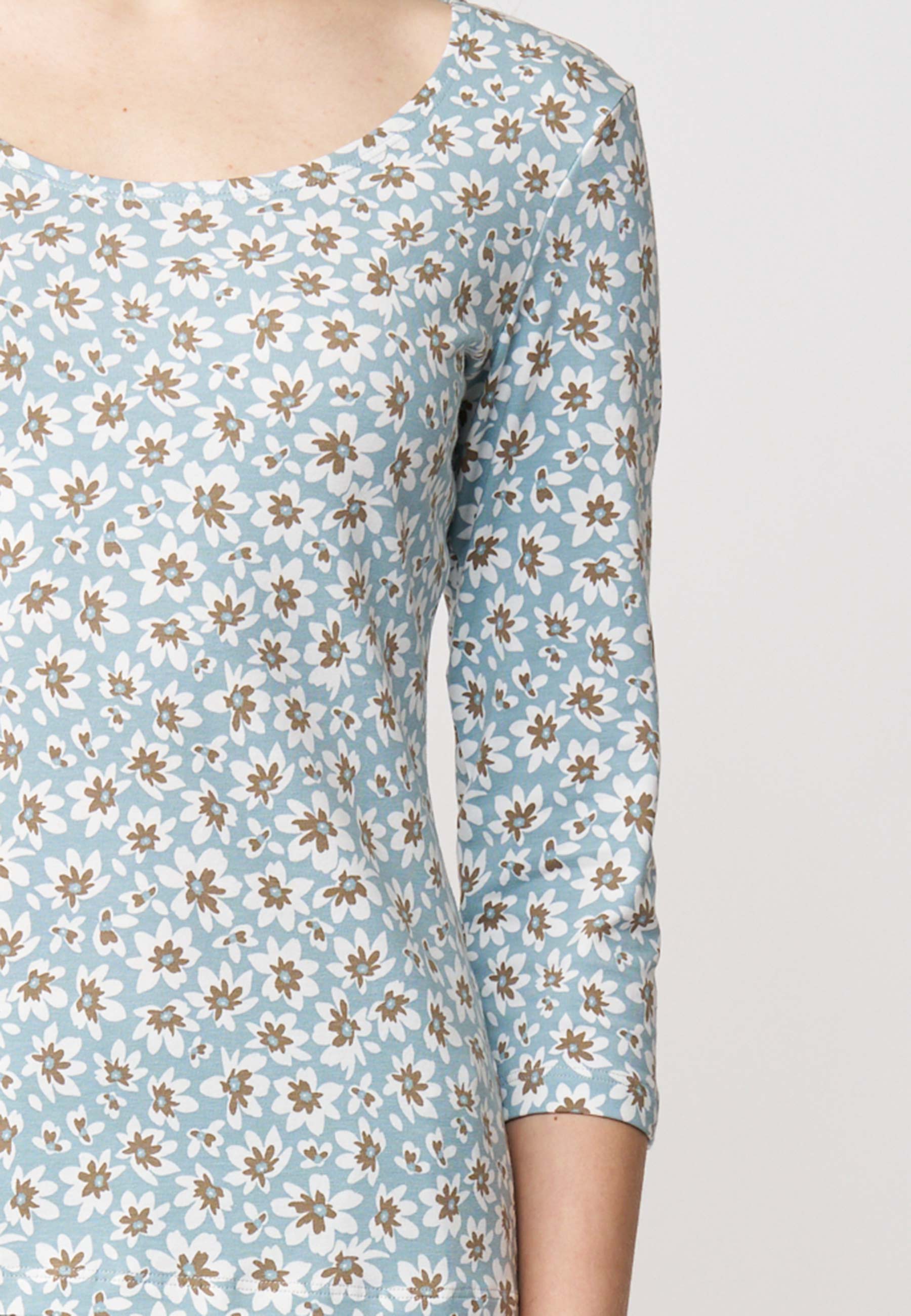 Shirt, Modell Leonie in Hellblau mit weiß-braunem Blütenmuster und 3/4-Arm, seitlich getragen