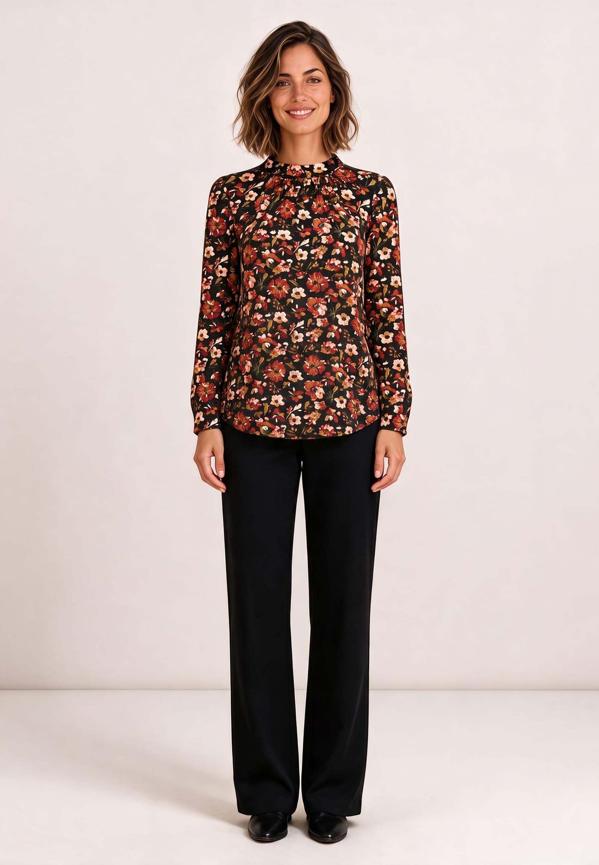 Shirt, Modell Holly mit Blumenmuster an lächelnder Frau und schwarzer Hose vor hellem Hintergrund