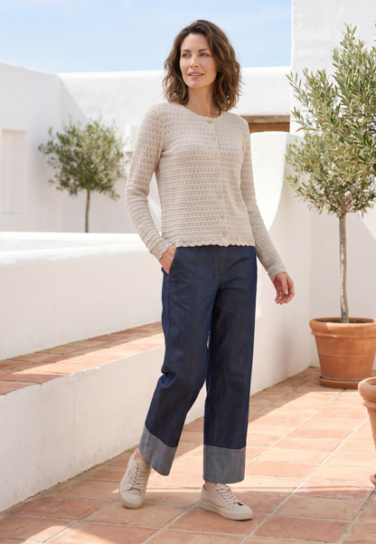 Strickjacke, Modell Marcelina in hellem Naturton mit Knopfleiste, leicht tailliert, natürliches Setting mit Pflanzen
